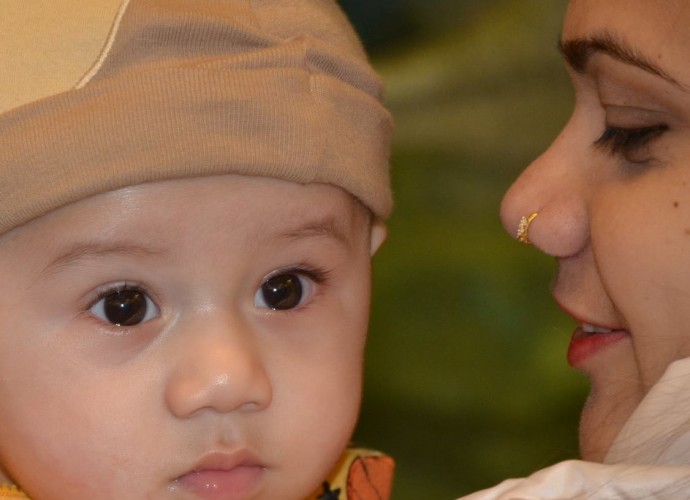 New mother Munna Subedi Monger gazes fondly at her son Sohan. Like many families, she faced years of separation before being reunited with her husband-to-be and starting their new life in Utica, NY. Dec. 2013. Photographer: Tek Monger.
