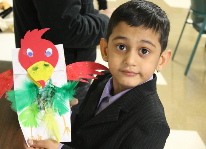 Ayouch Acharya participates in a puppet-making workshop at a local college in Dec. 2012. Bhutanese-Nepali boys have both ears pierced before their first birthday and many continue to wear earrings on special occasions later in life. Photographer: Katie Reilly.