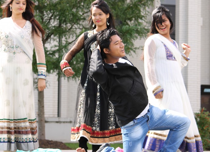 The crowd always appreciates dance teacher Nima Tamang and dancers Lovely Humagai, Sarada Yogi, and Pramila Rijal when they perform Nepali and Hindi songs. This photo was taken at the Mohawk Valley Community College (UMAF), Sept. 2013. Photographer: Katie Reilly.
