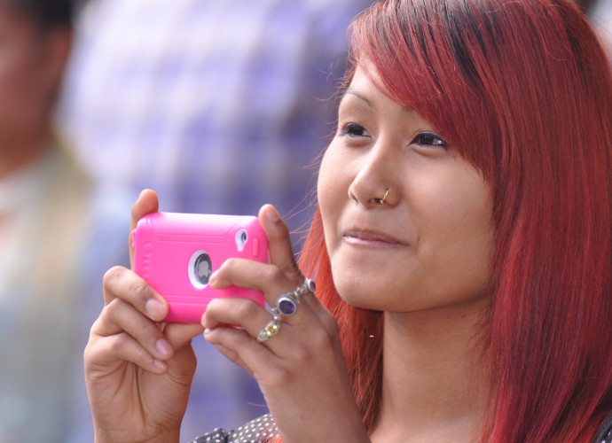 High school student and dancer Samjana Magar takes a photo of her relatives performing Nepali folk songs at the Utica Music and Arts Festival, Sept. 2012. Photographer: Lynne Browne.