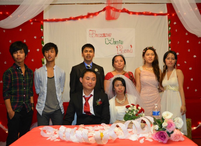 This photograph was taken at the Christian wedding reception of Sukraj and Bali Rai. Some of the Bhutanese-Nepali refugees in Utica, NY have maintained their Hindu or Buddhist faiths while the others have converted to Christianity. The Christians attend a local non-denominational church. They also maintain the tradition in which the bride goes to live with the groom, in this case a Utica resident. Nov. 2013. Photographer: Tek Monger.