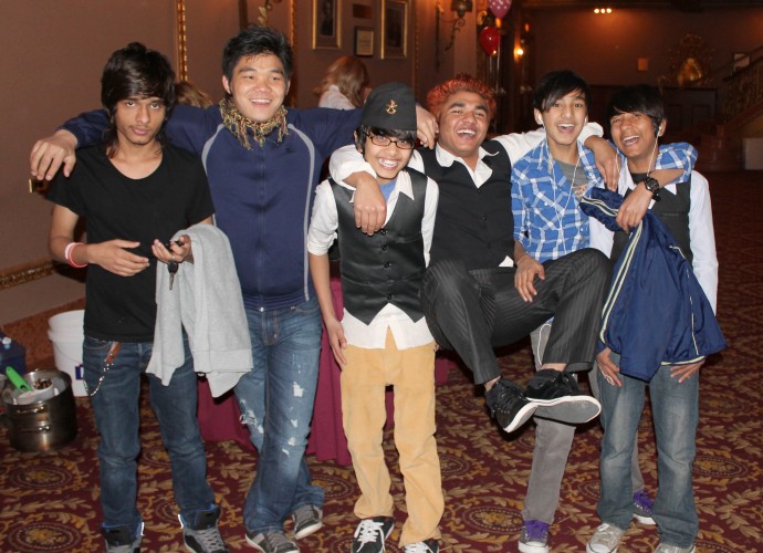 Bhutanese-Nepali teens enjoy themselves after a Nepali cultural performance at Culturefest on April 13, 2013 at the Stanley Theater in Utica, NY. These college and high school boys were all born in Nepal while their families were living in Beldangi 3 refugee camp in Eastern Nepal. They feel comfortable in native and Western dress, and are known in part for how frequently their change their hair color and style. Govinda Adhikari (far left), and his family were the first Bhutanese-Nepali family to be resettled in Utica, NY. Also pictured (from left to right) are Eshek Rai, Nava Adhikari, Krishna Adhikari, Rakesh Baniya and Anil Dharjee. Photographer: Katie Reilly.