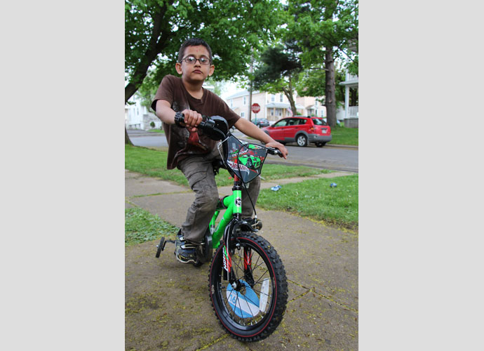Ayoush Acharya took some time biking around his house while his uncle was getting married upstairs. May, 2013. Photographer: Zora Thomova.