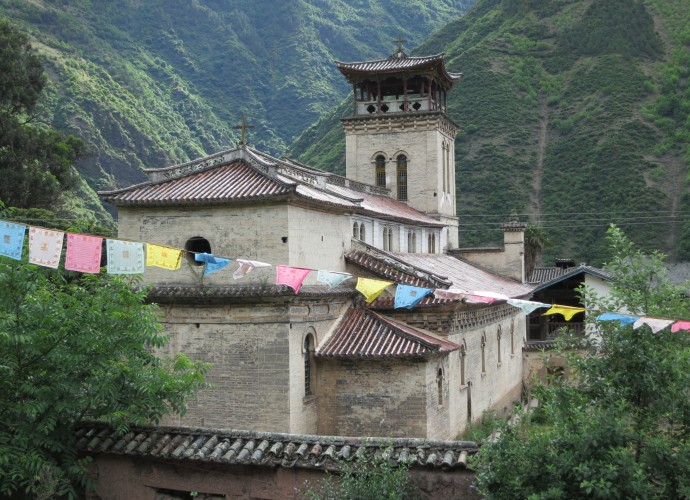 <b><p>Cizhong Church built in 1909.</b></p>
Wine in Cizhong village is made of grapes, primarily from a variety known as ‘Rose Honey’ that was introduced to the Tibetan areas of Yunnan Province by French and Swiss Catholic missionaries over a century ago. This <em>Vitis</em> cultivar is thought to contain at least some DNA from the species <em>vinifera</em> hybridized with other unconfirmed species, though its definitive origin is still unknown.  Assumed to be of missionary introduction and previously grown in Europe, it was wiped out by a blight and earlier thought to be extinct (Dangl 2011). By a twist of fate it still exists, but only in Yunnan Province (Galipeau 2015). 