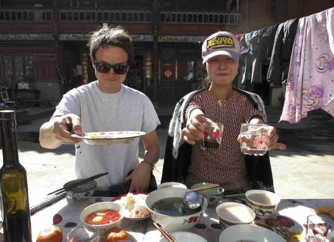 <b>Tourists entertained by Hongxing as he proudly served his wine.</b>