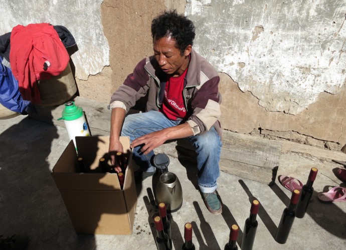 <b><p>Bottling ‘Cizhong’ labeled grape wine.</b></p>
Similarly, Wu Gongdi, whose household winemaking is discussed below and who is recognized as the first villager to renew a winemaking tradition in 1998, has also discussed wine, Catholicism, and local culture as being heavily linked together: 
<p><p><em>
I think Catholic culture is part of Tibetan culture, so wine is also part of Tibetan culture. But you also can’t talk about wine without talking about Catholic mass.  The fathers who were here even learned to speak Tibetan and I think this also makes wine part of Tibetan identity here…We were the first family to regularly make wine, so for my family yes, it is very important to our identity.
</em></p></p>