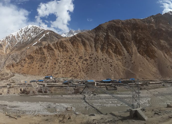 Hilsa, April 2017.
Construction of a military-style bridge over the Karnali river (left corner) was completed in November 2016 and inaugurated by then-Prime Minister Pushpa Kamal Dahal on December 20, making it possible for vehicles to cross the Karnali river for the first time. The fencing marks the border, and the border marker post can be seen close to the river. People usually carry commodities on their back across the border to the other side of the river. In March 2016, Prime Minister KP Oli signed ten pacts with China including the construction of a friendship bridge at Hilsa. Yet, by October 2017, there were no signs of work on the proposed bridge, which speaks to the broader and more common instances of unfulfilled promises Karnali residents are used to dealing with.