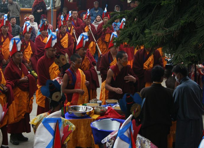 The medicinal vessels containing ground and unground ingredients are laid out on the table in front of Amchi Nyima (second from right) and Namsé (right). Monks accompany the act with ritual music and recitations.