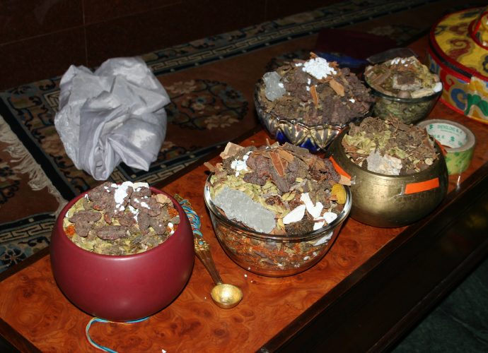 The vessels of the five cardinal points are filled with raw medicinal ingredients. The photograph shows some of them: white sugar (ka ra, one of the ‘three sweet [substances],’ mngar gsum), kaolin (cu gang), safflower (bal gur gum), cinnamon, as well as smaller (sug smel) and greater cardamom (ka ko la). A few ingredients, such as the ‘three sweet [substances]’ and cinnamon visible here, were included as additional substances according to the oral instructions of Yongdzin Rinpoche. They are not found in the mendrup recipe.