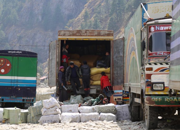 Porters unloading goods from a truck at Timure parking for customs clearance, Timure. In Timure, a large number of residents work in the parking area to load and unload imported goods from China that make it through customs. On a working day, hundreds of porters can be seen loading goods onto Nepalese trucks at the border. Depending on the season, a group consisting of five to six porters earn NRs 5000-8000 per day (roughly 44-70 $USD). According the residents, those working as porters at parking can earn between NRs 50,000-60,000 (roughly 445-530 $USD) during peaking season.