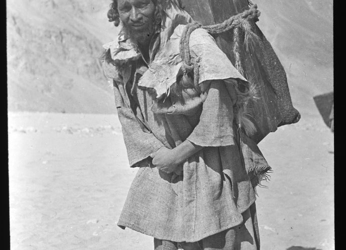 During the colonial period, and perhaps long before, one of the main exports from Baltistan was human labour. This Balti porter therefore represents a type that would have been familiar right across the Western Himalaya and Karakoram region, not only in Baltistan and Ladakh, but also in Kashmir and in British Indian hill stations such as Simla and Mussoorie. Balti men would often take on labouring jobs in these towns, especially during the winters when they had no agricultural work at home.
According to an entry in a photo album belonging to the Read family, this man’s name is Ghulam Hussein. He appears to be carrying a wooden chest, bound to his back by ropes, a much less convenient arrangement that a modern rucksack.